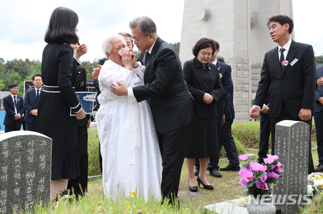 【광주=뉴시스】박진희 기자 = 문재인 대통령이 18일 오전 광주 북구 운정동 국립5.18민주묘지에서 열린 제39주년 5.18민주화운동 기념식에 참석한 뒤 희생자 안종필의 묘를 찾아 참배하고 어머니 이정임씨를 위로하고 있다. 2019.05.18.  pak7130@newsis.com