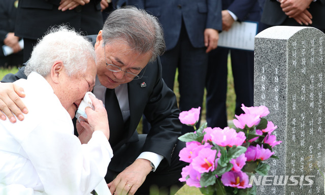 【광주=뉴시스】박진희 기자 = 문재인 대통령이 18일 오전 광주 북구 운정동 국립5.18민주묘지에서 열린 제39주년 5.18민주화운동 기념식에 참석한 뒤 희생자 안종필의 묘를 찾아 참배하고 어머니 이정임씨를 위로하고 있다. 2019.05.18.  pak7130@newsis.com