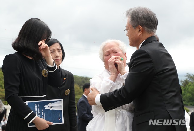 【광주=뉴시스】박진희 기자 = 문재인 대통령과 부인 김정숙 여사가 18일 오전 광주 북구 국립5·18민주묘지에서 열린 '제39주년 5·18민주화운동 기념식'을 마치고 5·18희생자 고 안종필 묘역을 찾아 참배하며 이정님씨를 위로하고 있다. 고 안종필(1964년5월28일~80년 5월 27일)씨는 5월 19일부터 광주항쟁 참여했고 27일까지 도청 지키다가 계엄군에 총탄 맞아 사망했다. 2019.05.18. pak7130@newsis.com