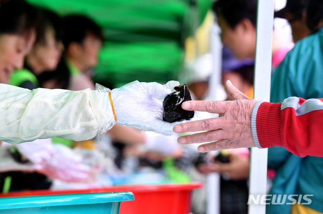 [광주=뉴시스] 손에서 손으로 건네지는 주먹밥 (사진=뉴시스DB) 2019.05.18. sdhdream@newsis.com