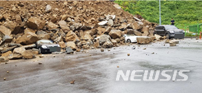 【광양=뉴시스】변재훈 기자 = 19일 전남 광양소방서에 따르면 지난 18일 오후 4시9분께 광양시 중동 한 아파트 인근 계단식 석재 축대(가로 90m·높이 10m) 중 일부가 붕괴돼 주차 차량 3대가 매몰, 파손됐으나 인명 피해는 없었다. 2019.05.19. (사진=전남 광양소방서 제공)&nbsp; photo@newsis.com