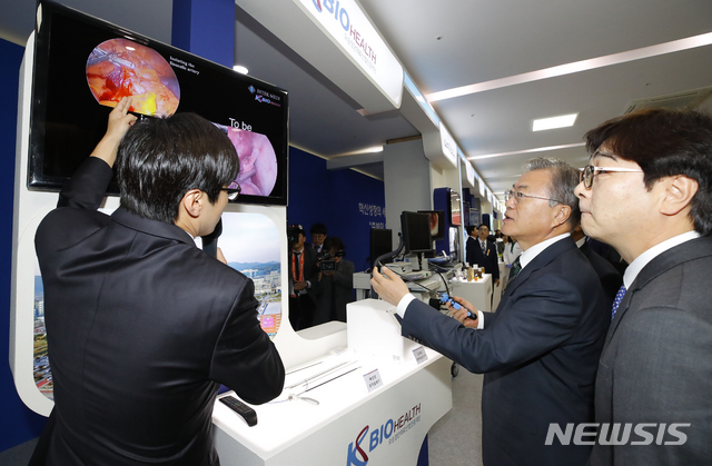 【청주=뉴시스】전신 기자 = 문재인 대통령이 22일 오전 충북 청주 오송 CV센터에서 열린 '바이오헬스 국가비전 선포식'에 앞서 암제거 등 복강경 수술시 수술환부에 광학기술을 이용, 혈관 위치를 정확하게 파악하고 혈관을 피해 조직을 절제, 출혈을 최소화하는 복강경 조직절제기를 살펴보고 있다. 2019.05.22. photo1006@newsis.com