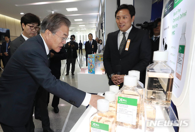 【청주=뉴시스】전신 기자 = 문재인 대통령이 22일 충북 청주시 오송 CV센터에서 열린 ‘바이오헬스 국가비전 선포식’에 앞서 (주)엑셀세라퓨틱스 전시부스에서 세포 치료제 생산의 원료 물질인 배양 배지를 살펴보고 있다. 2019.05.22.&nbsp; photo1006@newsis.com 