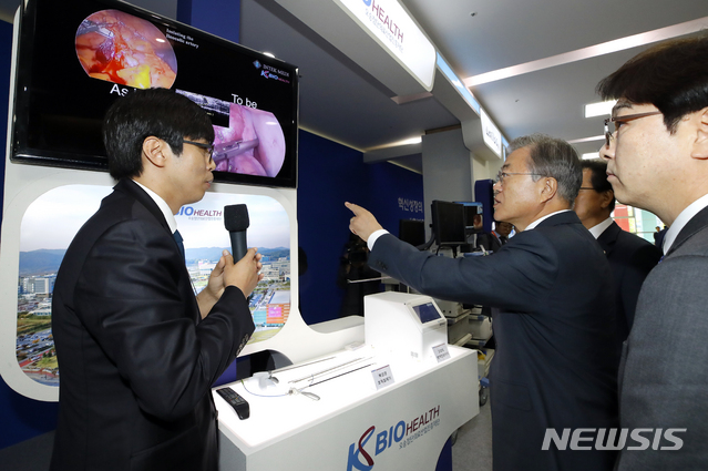 【청주=뉴시스】전신 기자 = 문재인 대통령이 22일 오전 충북 청주 오송 CV센터에서 열린 '바이오헬스 국가비전 선포식'에 앞서 암제거 등 복강경 수술시 수술환부에 광학기술을 이용, 혈관 위치를 정확하게 파악하고 혈관을 피해 조직을 절제, 출혈을 최소화하는 복강경 조직절제기를 살펴보고 있다. 2019.05.22. photo1006@newsis.com