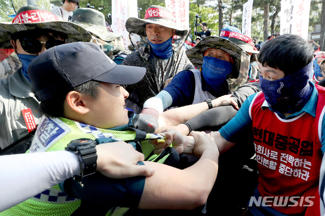 【서울=뉴시스】김병문 기자 = 대우조선해양 노조원들과 현대중공업 노조원 등 전국금속노동조합이 지난 22일 오후 서울 종로구 현대계동사옥 앞에서 '현대중공업 물적분할-대우조선 매각저지! 조선 구조조정 분쇄! 금속노조 결의대회'에서 사옥 진입을 위해 경찰을 끌어내고 있다. 2019.05.22.  dadazon@newsis.com