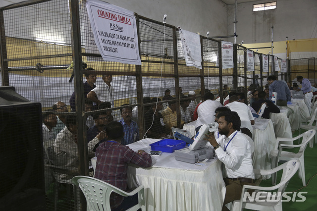 【하이데라바드(인도)=AP/뉴시스】인도 선거 관계자들이 23일 하이데라바드에서 지난 19일 종료된 인도 총선 개표 작업을 벌이고 있다. 초반 개표에서 나렌드라 모디 총리와 그의 집권당 인도인민당(BJP)이 229곳에서 선두를 달리며 56곳에서 선두를 차지한 제1 야당 국민회의당을 크게 앞서고 있는 것으로 나타났다. 272석을 얻으면 과반 의석을 넘어 집권이 가능하다. 2019.5.23