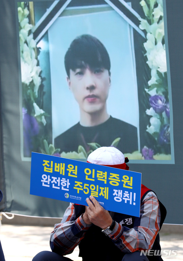 【서울=뉴시스】박진희 기자 = 23일 청와대 사랑채 인근에서 열린 '전국우정노조 지부장 상경 투쟁 결의대회'에 참석한 전국우정노동조합 한 조합원이 과로사로 숨진 동료 집배원 영정 앞에서 생각에 잠겨 있다. 2019.05.23. pak7130@newsis.com