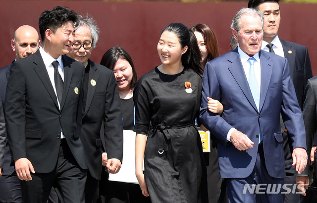  【김해=뉴시스】차용현 기자 = 23일 오후 경남 김해시 진영읍 봉하마을에서 열린 노무현 대통령 서거 10주기 추도식에서 참배를 마친 부시 전 미국 대통령이 노 전 대통령 손녀이자 아들 건호 씨 딸과 팔짱을 끼고 이동하고 있다. 왼쪽은 노 전 대통령 아들 건호 씨. 2019.05.23.&nbsp; photo@newsis.com 