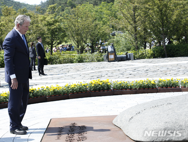 【김해=뉴시스】23일 경남 진해 봉하마을에서 열린 고 노무현 대통령 10주기 추도식에 참석한 조지 부시 전 미국 대통령이 노 전 대통령 묘역을 참배한 뒤 바라보고 있다. 2019.05.23. (사진=노무현재단 제공) photo@newsis.com