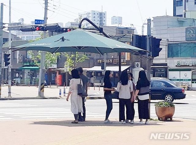 【하남=뉴시스】 문영일 기자 = 경기 하남시에 24일 폭염경보가 내려진 가운데 기온이 33℃를 웃돌면서 도로를 횡단하려는 시민들이 인도에 설치된 가림막에 더위를 피하고 있다. 2019.05.24. ctdesk@newsis.com