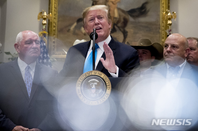 【워싱턴=AP/뉴시스】도널드 트럼프 미국 대통령이 23일(현지시간) 백악관 루즈벨트룸에서 소니 퍼듀 농무장관(왼쪽) 등과 함께 미국 농민과 목장주들을 지원하기 위한 간담회를 열고 기자 질문에 답하고 있다. 2019.05.24.