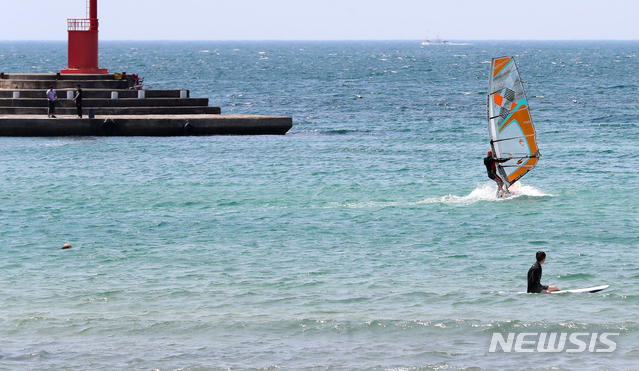 【제주=뉴시스】우장호 기자 = 낮 기온이 33.1도까지 오르며 제주도 역대 5월 최고기온을 경신한 24일 오후 제주시 이호해수욕장에서 한 서퍼가 시원하게 물살을 가르며 윈드서핑을 즐기고 있다. 2019.05.24. woo1223@newsis.com