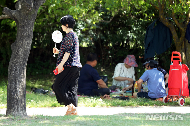 【서울=뉴시스】이윤청 기자 = 전국에 무더위가 계속되며 서울 낮 최고기온 30도를 기록한 26일 서울 광진구 뚝섬 한강공원에서 한 시민이 부채질을 하고 있다. 2019.05.26. radiohead@newsis.com