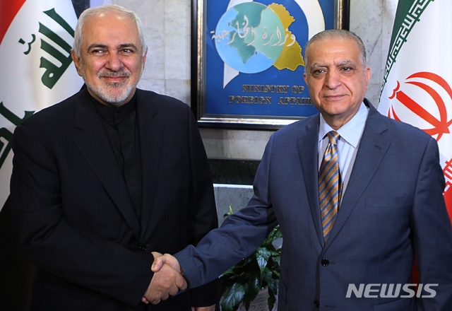 【바그다드=AP/뉴시스】모하메드 알리 알하킴 이라크 외무장관(오른쪽)은 26일(현지시간) 이라크 바그다드에서 모하마드 자바드 자리프 이란 외무장관과 회동한 뒤 공동 기자회견에서 미국과 이란을 중재하겠다는 뜻을 내비쳤다. 사진은 알하킴 외무장관과 자리프 외무장관이 악수하는 모습. 2019.05.27