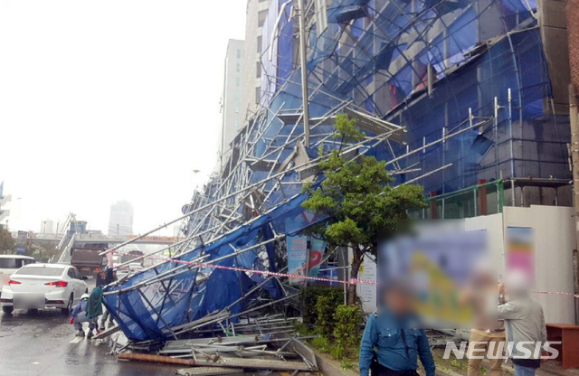 【부산=뉴시스】 27일 낮 12시 28분께 부산 중구의 한 오피스텔 신축현장에 설치된 외벽 안전펜스( 2~7층 높이)가 쓰러져 도로 1개 차로를 덮쳤다.2019.05.27. (사진=부산경찰청 제공)photo@newsis.com 