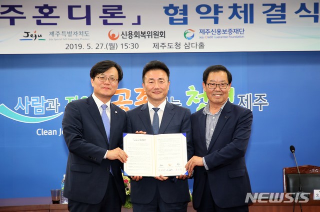 【제주=뉴시스】 27일 오후 도청 삼다홀에서 전성태(가운데) 제주행정부지사, 김중식(왼쪽) 신용회복위원회사무국장, 오인택 제주신용보증재단 이사장이 금융취약계층의 소액대출지원사업인 ‘제주혼디론’ 협약식을 마친 후 협약서를 들어보이고 있다. (사진= 제주도청 제공) 