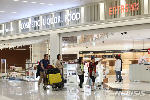【인천공항=뉴시스】김진아 기자 = 지난 28일 인천공항 제2여객터미널 입국장에서 가족들이 입국장면세점 '엔타스듀티프리' 개장 준비 모습을 바라보고 있다. 입국장 면세점이 이달 31일부터 문을 연다. 2019.05.29. bluesoda@newsis.com