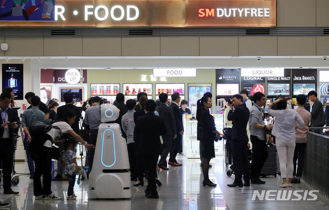 【인천공항=뉴시스】배훈식 기자 = 인천국제공항 입국장면세점을 찾은 관광객들이 제품을 고르고 있다. 2019.05.31. dahora83@newsis.com