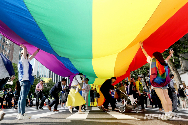 【서울=뉴시스】김병문 기자 = 1일 오후 서울 중구 명동·을지로 일대에서 열린 서울퀴어문화축제 퍼레이드 무지개 현수막 아래로 시민들이 횡단보도를 건너고 있다. 2019.06.01.&nbsp;&nbsp; dadazon@newsis.com