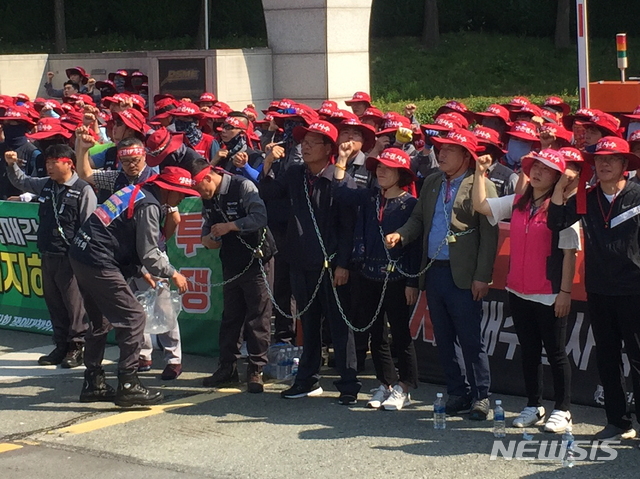 【거제=뉴시스】 대우조선해양 노조는 3일 현대중공업 현장실사단의 진입을 막기 위해 정문뿐 아니라 동문·남문 등 나머지 5곳의 출입문에도 인력을 배치했고, 이들 중 일부는 서로의 몸을 쇠사슬로 연결해 현장실사단을 막아서는 모습을 보이기도 했다. 2019.06.03. kims1366@newsis.com 