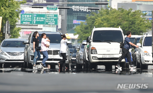 【대구=뉴시스】우종록 기자 = 대구 낮 기온이 33도를 웃도는 등 무더운 날씨를 보인 3일 오후 대구 중구 덕산동 동아백화점 쇼핑점 앞 대로에 지열로 인한 아지랑이가 피어오르고 있다. 2019.06.03. wjr@newsis.com