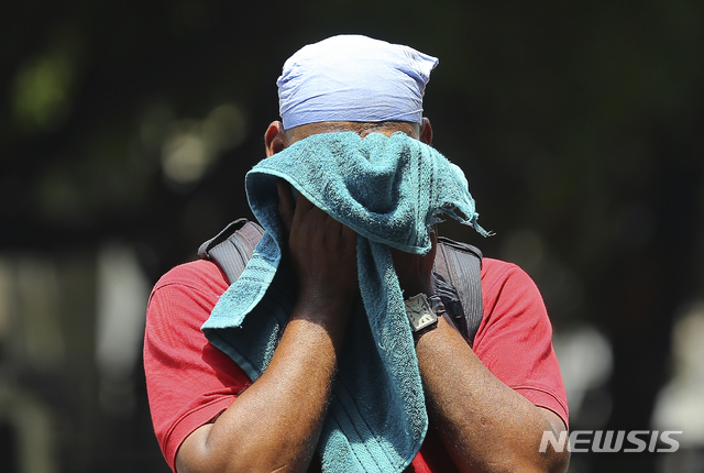 【하이데라바드=AP/뉴시스】3일(현지시간) 고온다습한 날씨의 인도 하이데라바드에서 한 남성이 수건으로 얼굴의 땀을 닦고 있다.인도 곳곳에서 섭씨 45도가 넘는 무더위가 이어져 폭염으로 인한 열사병 우려가 확산하고 있으며 많은 주민이 물 부족으로 빨래는커녕 씻지도 못하는 것으로 알려졌다. 2019.06.03.