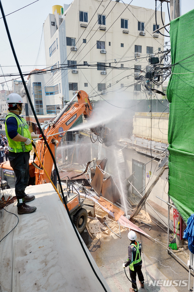【대구=뉴시스】우종록 기자 = 대구 성매매 집결지인 속칭 ‘자갈마당’ 철거작업이 시작된 4일 오전 대구 중구 도원동 자갈마당에서 작업자들이 중장비를 동원해 건물을 철거하고 있다. 자갈마당 부지 및 주변 일대는 지하 6층, 지상 49층 규모로 아파트 886가구와 오피스텔 256세대의 주상복합단지 등이 들어설 계획이다. 준공 예상 시기는 2023년 3월이다. 2019.06.04.wjr@newsis.com