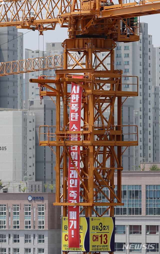 【세종=뉴시스】이영환 기자 = 한국노총과 민주노총 등 타워크레인 양대 노조가 무기한 총파업에 들어간 4일 세종시의 한 공사장에 타워크레인이 멈춰 서있는 가운데 '시한폭탄 소형타워크레인 즉각폐기' 플래카드가 걸려있다. 2019.06.04. 20hwan@newsis.com