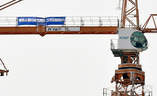 【경산=뉴시스】우종록 기자 = 타워크레인 건설노조가 총파업에 들어간 4일 오후 경북 경산시 중산동 한 아파트 공사 현장에서 소형 무인 타워크레인 철폐를 요구하는 노동자의 점거로 크레인이 가동을 멈춘 채 서 있다. 2019.06.04.wjr@newsis.com