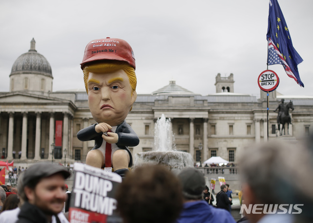 【런던=AP/뉴시스】 트럼프 미 대통령의 국빈 방문을 반대하는 영국 시위자들이 4일 런던 도심 트라팔가 광장에 운집한 가운데 황금색 변기에 앉아 트윗 문자질을 하는 트럼프 '인형'이 가운데에 높이 앉아 있다. 2019. 6. 4. 