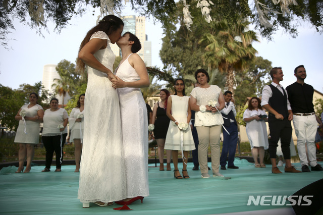 【텔아비브=AP/뉴시스】지난 2019년6월4일(현지시간) 이스라엘 텔아비브에서 열린 합동 동성 결혼식에 동성 커플들이 참여해 결혼식을 올리고 있다. 23쌍의 동성 커플을 포함, 수백 명의 이스라엘 사람이 '게이 프라이드 주간'을 앞두고 동성혼 권리를 요구하며 합동결혼식에 참가했다. 2019.06.05.