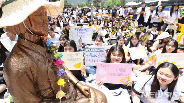 【서울=뉴시스】 전진환 기자 = 일본군 성노예제 문제 해결을 위한 정기 수요집회가 열린 지난 6월5일 오후 서울 종로구 옛 일본대사관 앞에서 학생들이 피켓을 들고 있다. 2019.06.05. amin2@newsis.com