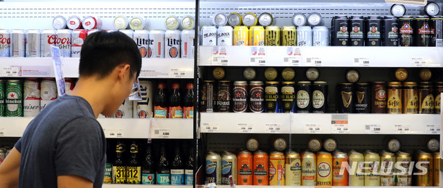 【서울=뉴시스】 전진환 기자 = 정부는 2017년과 2018년 출고량과 세액을 바탕으로 맥주의 기준세율을 ℓ당 830.3원으로 정했으며 막걸리를 포함한 탁주의 경우 ℓ당 41.7원으로 결정했다.&nbsp; 양을 기준으로 세금이 부과되면서 캔ㆍ병ㆍ페트ㆍ케그(생맥주) 등 용기별로 세부담이 달라진다. 국내에서 맥주를 생산하는 3사(OB맥주ㆍ하이트진로ㆍ롯데주류) 기준 캔맥주에 부과되는 주세는 ℓ당 830원으로 현재보다 291원 저렴해진다. 그만큼 가격이 내려갈 여지가 생겨수입맥주처럼 국산 캔맥주도 이른바 '4캔에 만원' 행사를 할 수 있게 됐다. 5일 서울의 한 마트에서 고객이 수입맥주를 살펴보고 있다. 2019.06.05.&nbsp; amin2@newsis.com