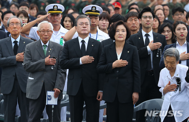 【서울=뉴시스】전신 기자 = 문재인 대통령과 김정숙여사가 6일 서울 동작구 국립서울현충원에서 열린 제64회 현충일 추념식에서 참석자들과 함께 국기에 경례하고 있다. 2019.06.06. photo1006@newsis.com