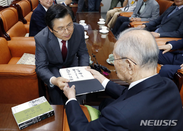 【서울=뉴시스】최동준 기자 = 황교안 자유한국당 대표가 10일 서울 용산구 전쟁기념관 군사 편찬연구 자문위원장실에서 백선엽 예비역 대장을 예방, '백선엽의 6.25 징비록' 책을 선물 받고 있다. 2019.06.10. photocdj@newsis.com