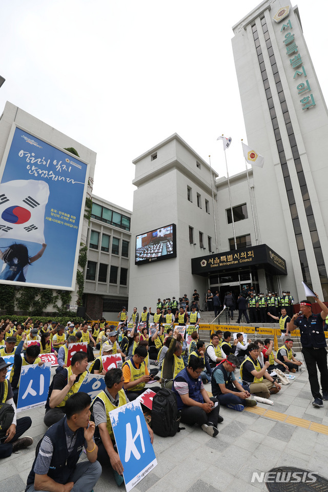【서울=뉴시스】김진아 기자 = 전국공공운수노조 서울지역공무직지부 관계자들이 10일 제287회 정례회 개회식이 열린 서울시의회 앞에서 공무직 처우개선을 위한 조례제정을 촉구하는 결의대회를 하고 있다. 2019.06.10.&nbsp; bluesoda@newsis.com (사진=뉴시스DB)