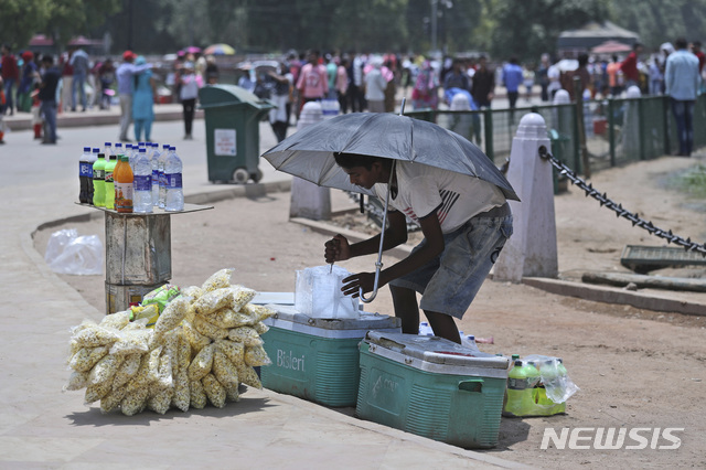 【뉴델리=AP/뉴시스】10일(현지시간) 인도 뉴델리 공원에서 한 거리 판매원이 차가운 음료 보존을 위해 아이스박스에 얼음을 넣고 있다.&nbsp; 인도 라자스탄주 일부 지역에서는 최고기온이 섭씨 48도까지 치솟는 등 극심한 폭염 상황이 인도 북부와 서부 지역을 휩쓸고 있다. 2019.06.10.