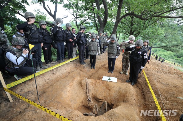【철원=뉴시스】사진공동취재단 = 정경두 국방부 장관이 11일 오전 강원 철원군 비무장지대 우리쪽 지역인 화살머리고지일대에서 6·25 전사자 유해발굴 작업으로 발굴된 우리군 전사자 유해 앞에서 경례를 하고 있다. 2019.06.11. photo@newsis.com