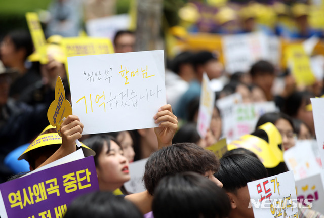 [서울=뉴시스]박미소 기자 = 12일 오후 서울 종로구 구 주한일본대사관 앞에서 열린 1391차 일본군 성노예제 문제 해결을 위한 정기 수요시위에서 학생들이 구 일본대사관을 향해 손피켓을 들고 있다. 2019.06.12.  misocamera@newsis.com