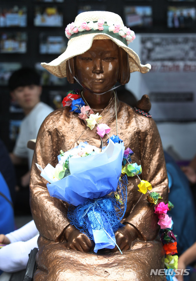 【서울=뉴시스】박미소 기자 = 지난 12일 오후 서울 종로구 구 주한일본대사관 앞에서 열린 1391차 일본군 성노예제 문제 해결을 위한 정기 수요시위에서 모자를 쓴 소녀상 위로 꽃다발이 놓여 있다. 2019.06.12. misocamera@newsis.com