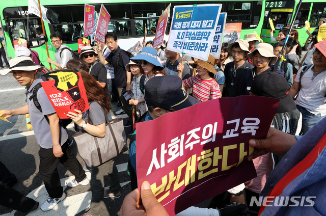 【서울=뉴시스】이영환 기자 = 12일 오후 전국교직원노동조합(전교조) 조합원들이 정부의 '법외노조 취소 거부'를 규탄하며 행진하는 가운데, 전교조 해체를 촉구하는 보수학부모 단체 관계자들이 피켓을 들고 있다. 2019.06.12.&nbsp; 20hwan@newsis.com