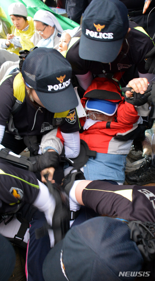 【밀양=뉴시스】안지율 기자 = 지난 2014년 6월11일 오전 경남 밀양시 부북면 위양리 평밭마을 129번 송전탑 공사 현장에서 움막 철거 행정대집행이 진행되는 가운데 한 주민이 경찰에게 끌려 나가고 있다. 2014.06.11.alk9935@newsis.com