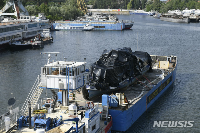【부다페스트=AP/뉴시스】지난 11일(이하 현지시간) 인양된 유람선 '허블레아니'가 13일 덮개에 덮인 채 바지선에 실려 헝가리 부다페스트 북부의 한 도크에 도착하고 있다. 헝가리 법원은 지난달 29일 '허블레아니'를 들이받아 침몰 사고를 낸 혐의를 받는 '바이킹 시긴'호 유리 C 선장의 보석 신청을 받아들여 석방했다고 밝혔다. 2019.06.14.