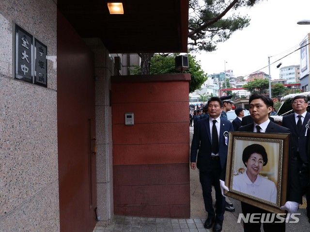 【서울=뉴시스】이영환 기자 = 고 이희호 김대중평화센터 이사장의 영정이 14일 오전 서울 동교동 사저와 김대중도서관을 들른 뒤 사저 대문 옆에 나란히 걸린 '김대중·이희호' 문패 앞에 잠시 멈춰서 있다. 2019.06.14.&nbsp; photo@newsis.com