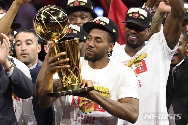 【오클랜드=AP/뉴시스】 토론토 랩터스가 14일(한국시간) 미국 캘리포니아주 오클랜드의 오라클 아레나에서 열린 골든스테이트 워리어스와의 2018~2019 NBA 파이널(7전4선승제) 6차전에서 114-110으로 승리, 시리즈 전적 4승2패로 1995년 창단 후 처음으로 우승을 차지했다. 파이널 최우수선수(MVP) 카와이 레너드가 우승 트로피를 들고 있다.