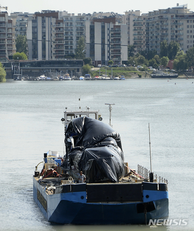 【부다페스트=AP/뉴시스】지난 11일(이하 현지시간) 인양된 유람선 '허블레아니'가 13일 덮개에 덮인 채 바지선에 실려 헝가리 부다페스트 북부의 한 도크로 향하고 있다. 2019.07.05.