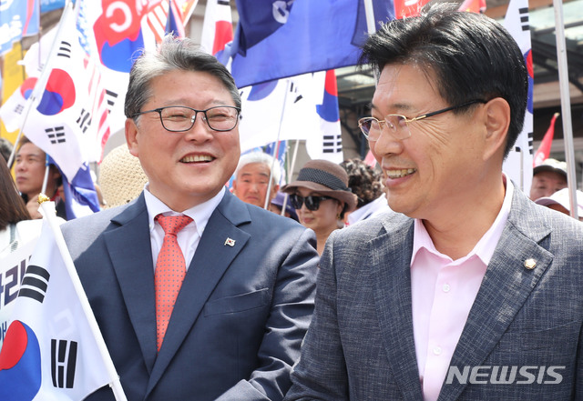 【서울=뉴시스】박미소 기자 = 자유한국당 홍문종(오른쪽) 의원이 15일 오후 서울 용산구 서울역광장에서 열린 태극기집회에서 대한애국당 조원진 대표와 함께 웃고 있다. 이날 홍문종 의원은 태극기 집회에서 탈당 선언을 한 후 대한애국당 조원진 대표와 함께 '신공화당'을 만들기로 발표했다. 2019.06.15. misocamera@neswsis.com