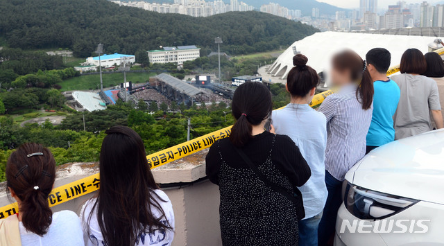 【부산=뉴시스】 하경민 기자 = 15일 부산 연제구 아시아드보조경기장에서 방탄소년단(BTS) 팬클럽 '아미' 2만여 명이 참여한 가운데 BTS 팬미팅 행사가 열리고 있는 가운데 인근 고지대에서 시민들이 공연장을 지켜보고 있다. 2019.06.15.&nbsp; yulnetphoto@newsis.com