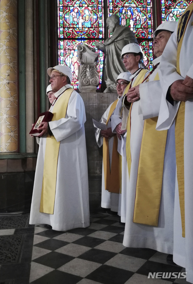 【파리= AP/뉴시스】지난 4월 15일 대화재로 불탄 프랑스의 노트르담 대사원에서 6월 15일 두 달만에 처음 열린 미사. 파리 대주교를 비롯한 사제들이 천정 붕괴 위험이 있다는 전문가 지적에 따라서 모두 하얀 작업용 안전헬멧을 착용하고 있다.&nbsp; 