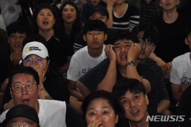 【대전=뉴시스】함형서 기자 = 2019 U-20월드컵 대한민국과 우크라이나의 결승전 경기가 열린 16일 오전 대전시 중구 중앙로 거리에서 시민들이 축구 중계를 보고 있다. 2019.06.16. foodwork@newsis.com